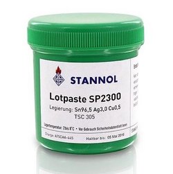 Auf dem Bild ist eine grüne Lotpastendose mit weißem Etikett zu sehen. Das Etikett ist mit dem Stannol-Logo sowie den Produktspezifikationen der Lotpaste SP2300 versehen.