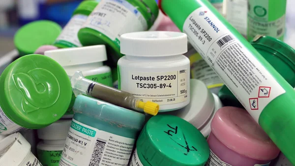 Auf dem Bild sind eine Vielzahl an alten Lotpasten-Dosen und -Kartuschen zu sehen.