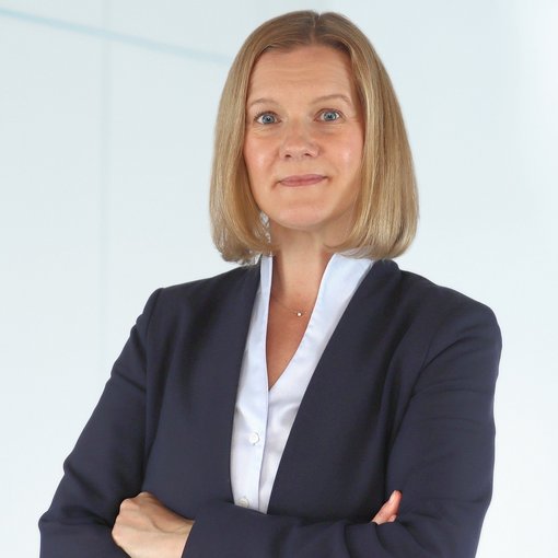 Auf dem Bild ist eine Frau mit halblange, blonden Haaren zu sehen. Sie trägt eine hellblaue Bluse und einen blauen Blazer. Sie lächelt freundlich in die Kamera.